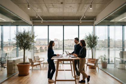 Espace de coworking moderne à Bordeaux avec vue sur la Garonne, professionnels collaborant autour d'un bureau debout