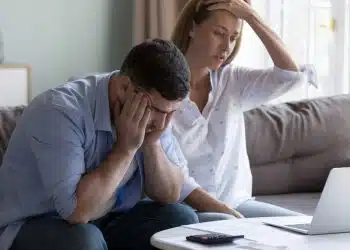 Stressed spouses manage family finances, analyze expenses, check savings and budget, looks disappointed due to mortgage arrears, unpaid utility bills, debt notice. Lack of money, high utility concept